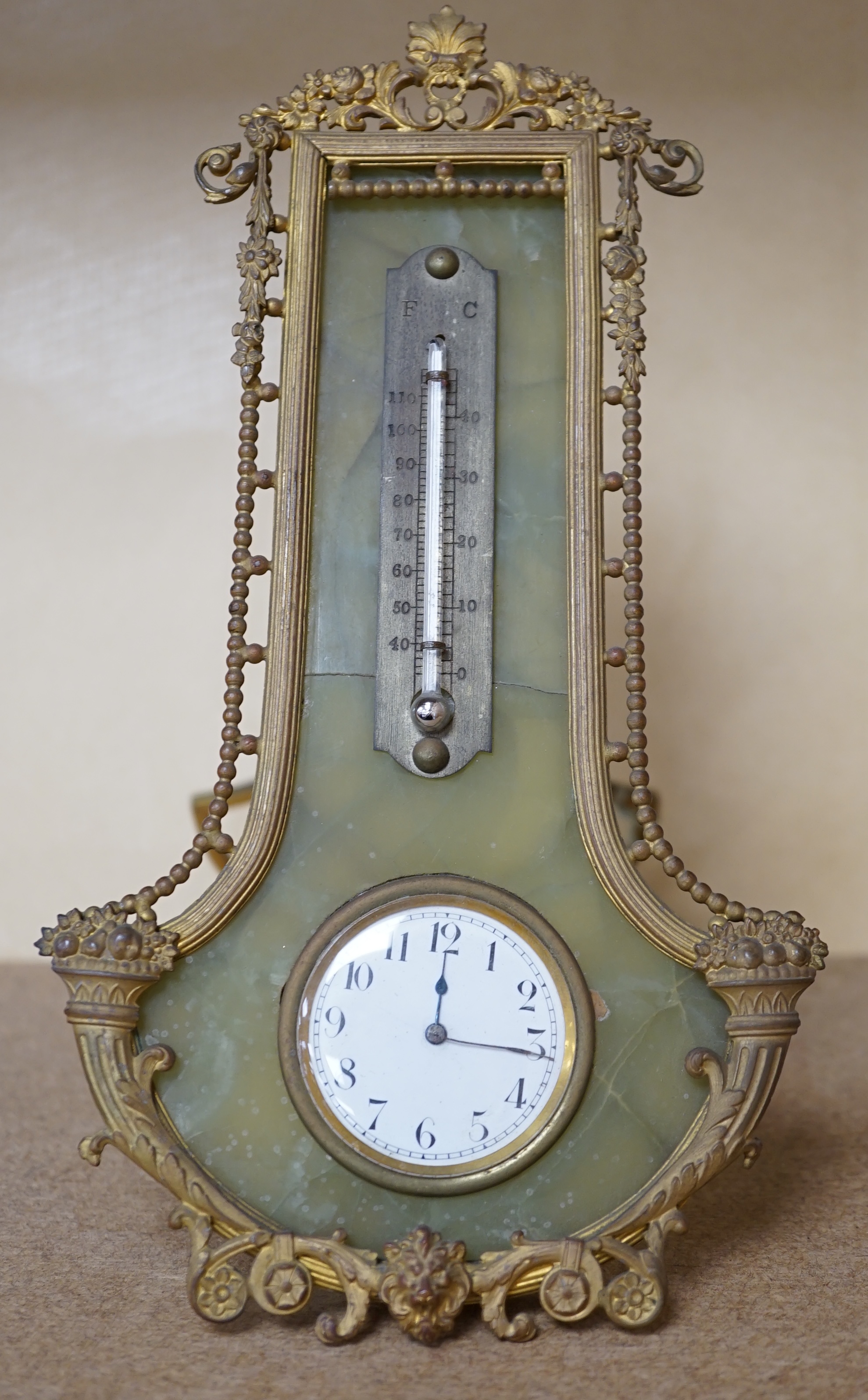 An onyx and gilt metal easel timepiece and thermometer, 20cm high. Condition - fair